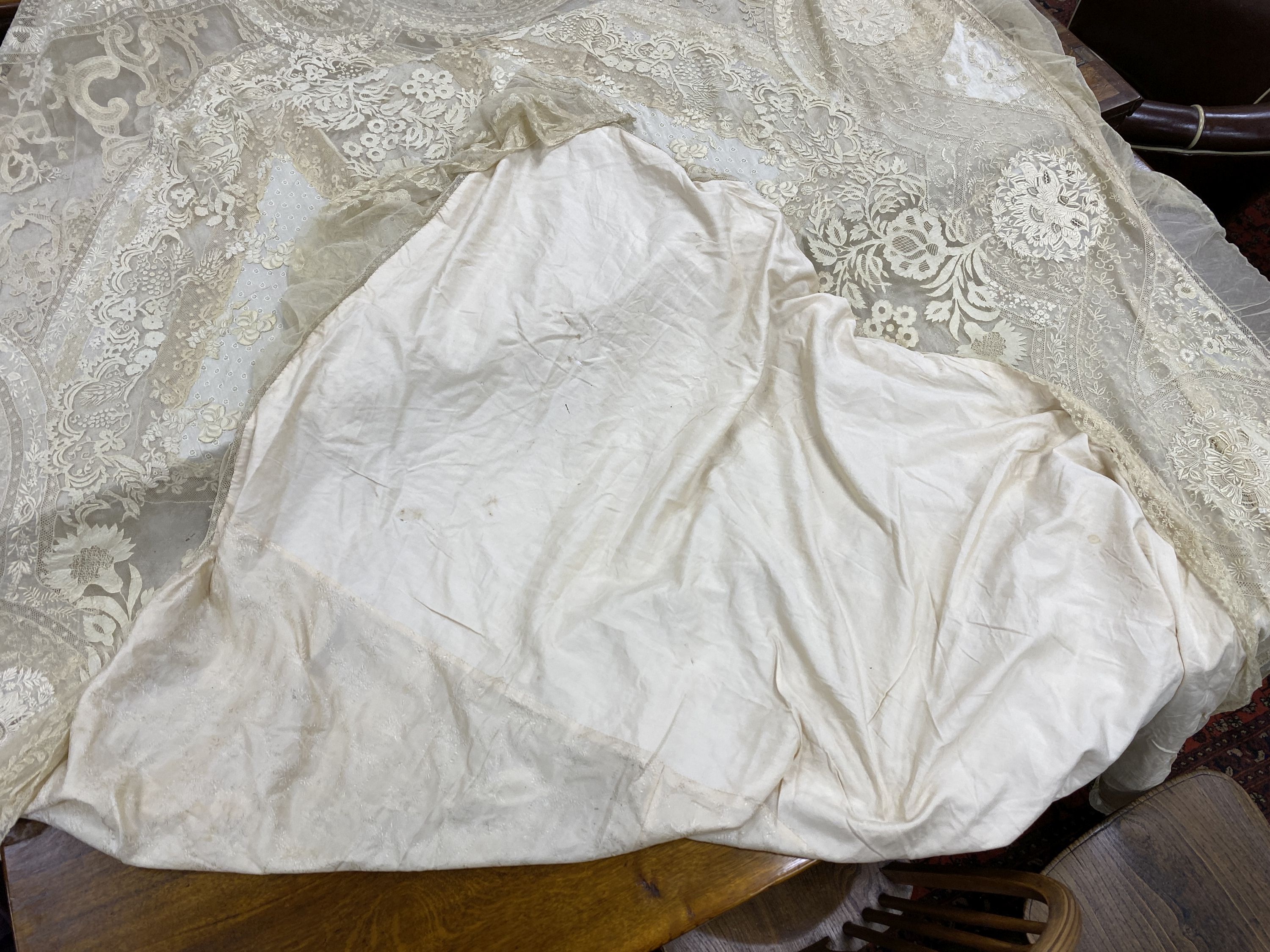 An Edwardian hand made lace bedspread. Hand sewn using finely spun lawn, decorated with Carrickmacross and white work embroidery, edged in bobbin lace. Possibly made as part of a trousseau.